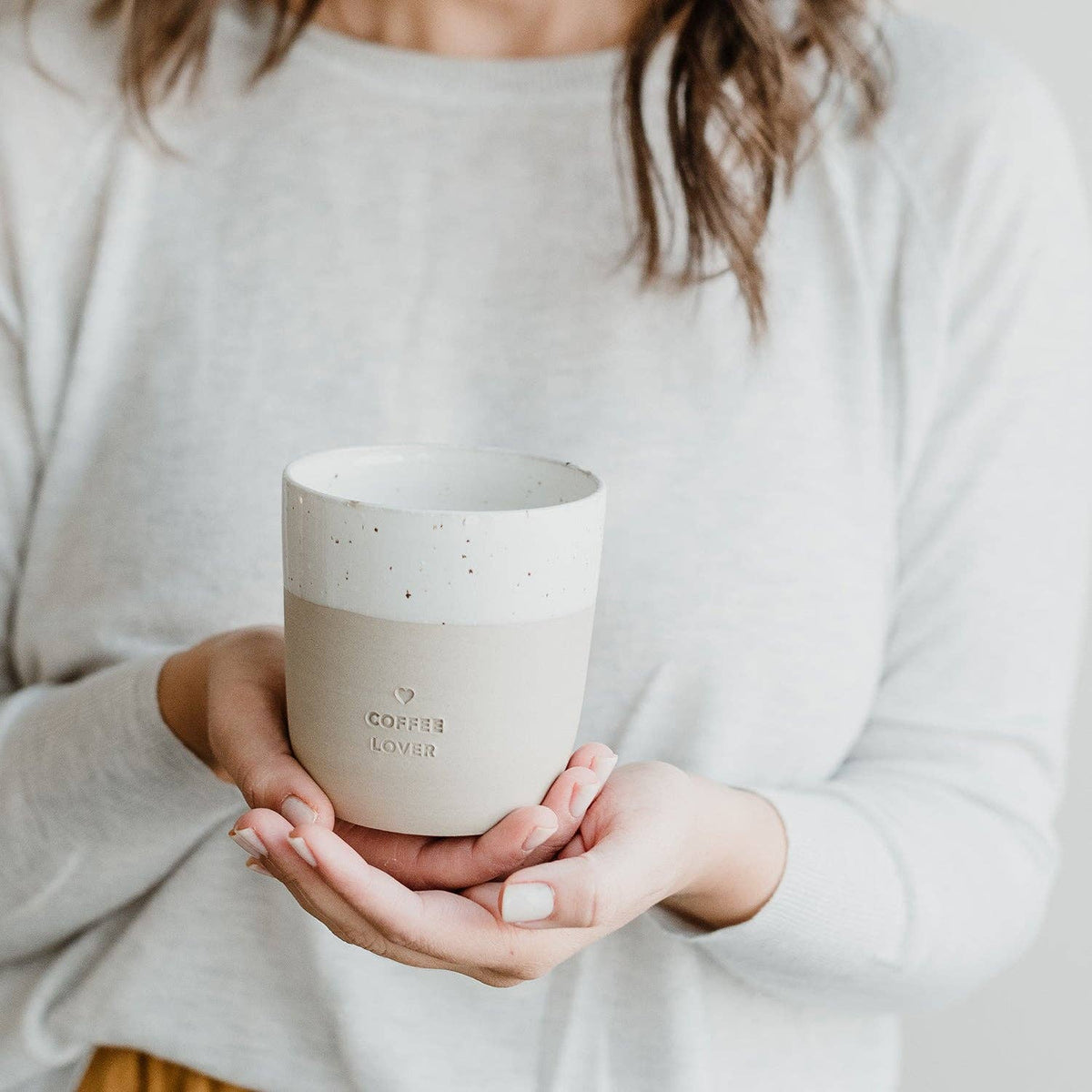 Kvinde der holder et kaffekrus med teksten Coffee Lover til Java Mocca kaffe.