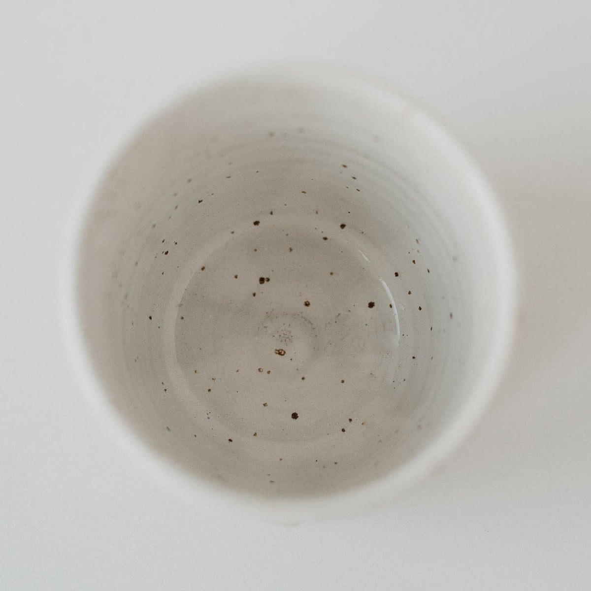 Håndlavet keramik MAMA kaffekop set oppefra med hvid glasur og fine prikker.