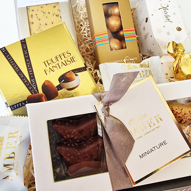 Nærbillede af luksuriøs julekurv med Summerbird Amber chokolade og Truffes Fantaisie delikatesser.