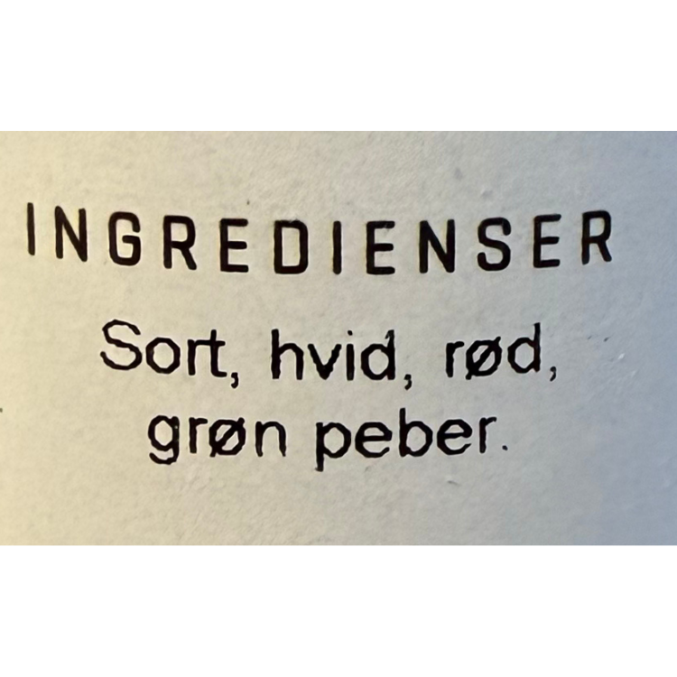Nærbillede af ingrediensliste på krydderi med sort, hvid, rød og grøn peber.