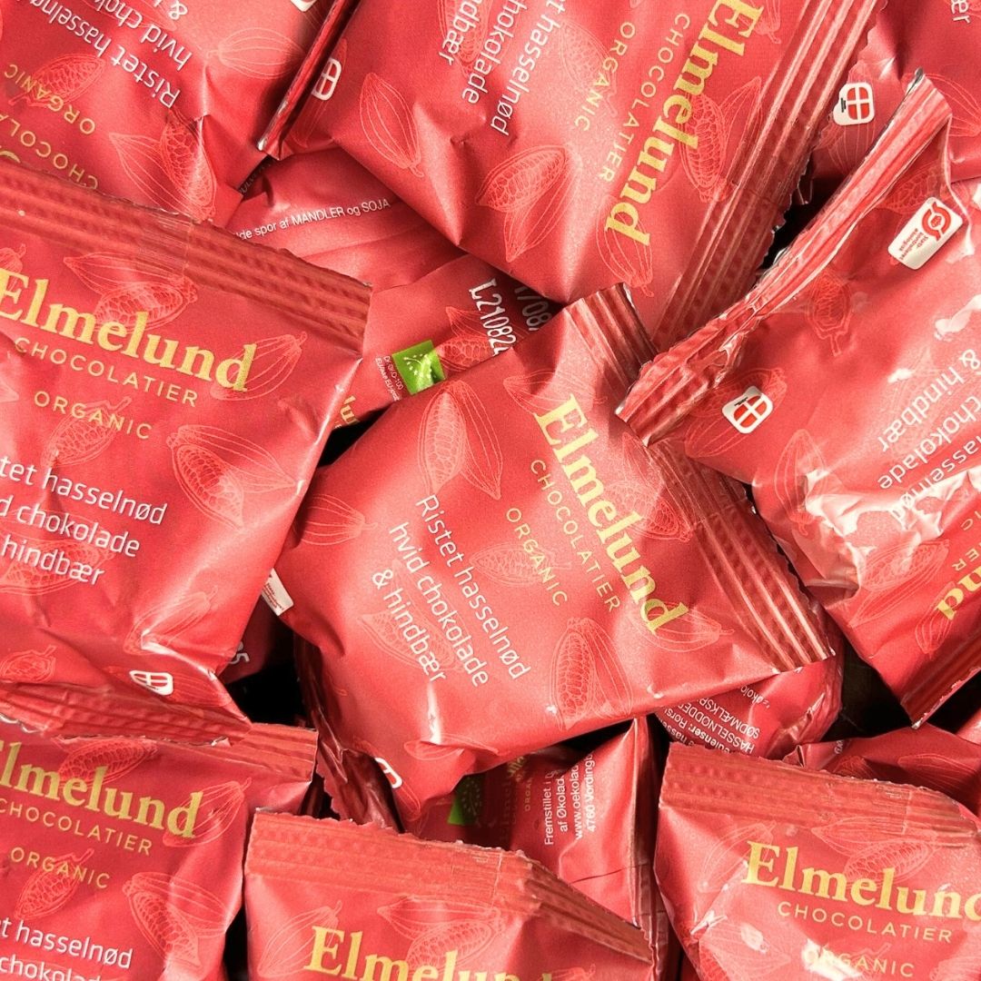 Røde poser med økologisk ristet hasselnød med hvid chokolade og hindbær fra Elmelund Chocolatier.