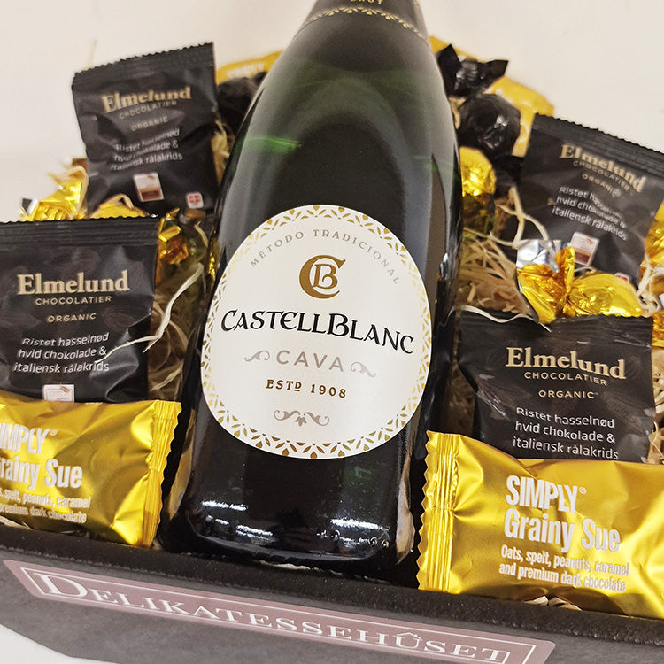 Tætpakket gavekurv med en flaske Castellblanc Cava og eksklusiv chokolade fra Elmelund og Simply Chocolate.