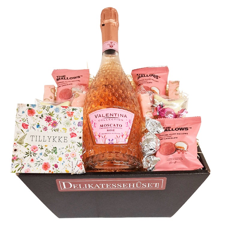 Lyserød gavekurv med Moscato Rose, The Mallows skumfiduser og et dekorativt Tillykke kort.