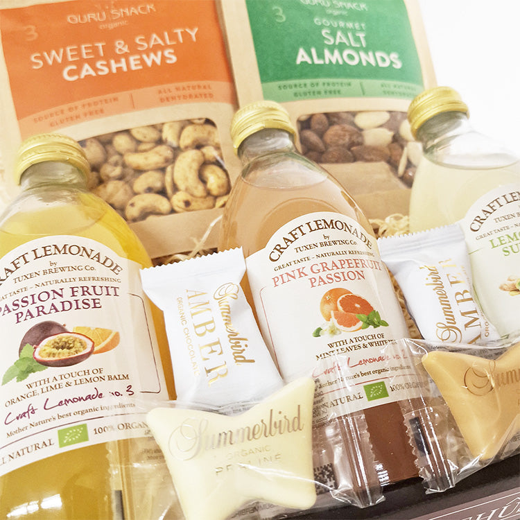 Sød gavekurv med økologiske lemonader, nødder og Summerbird-chokolade – klar til hjemlevering.