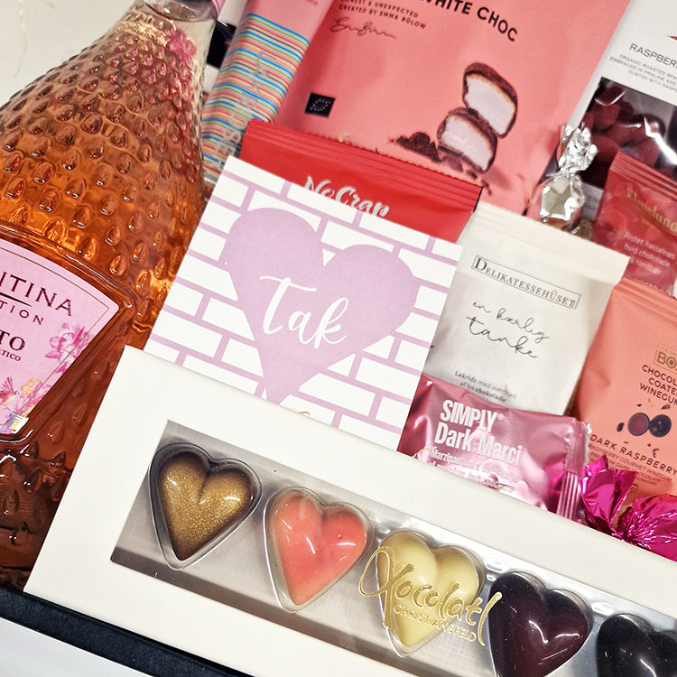 Pink gavekurv med Moscato vin, hjertechokolade og et kort med teksten Tak.