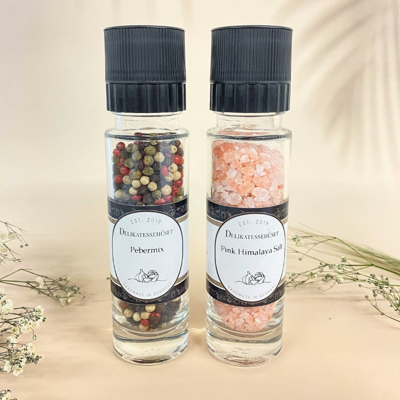 To kværne med henholdsvis pebermix og pink Himalaya salt fra Delikatessehuset stående side om side.