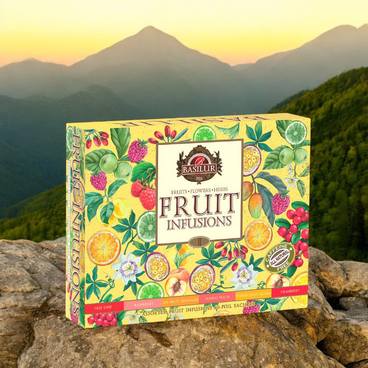 Gaveæske med 60 tebreve fra Basilur Fruit Infusions placeret i naturen foran bjerge.