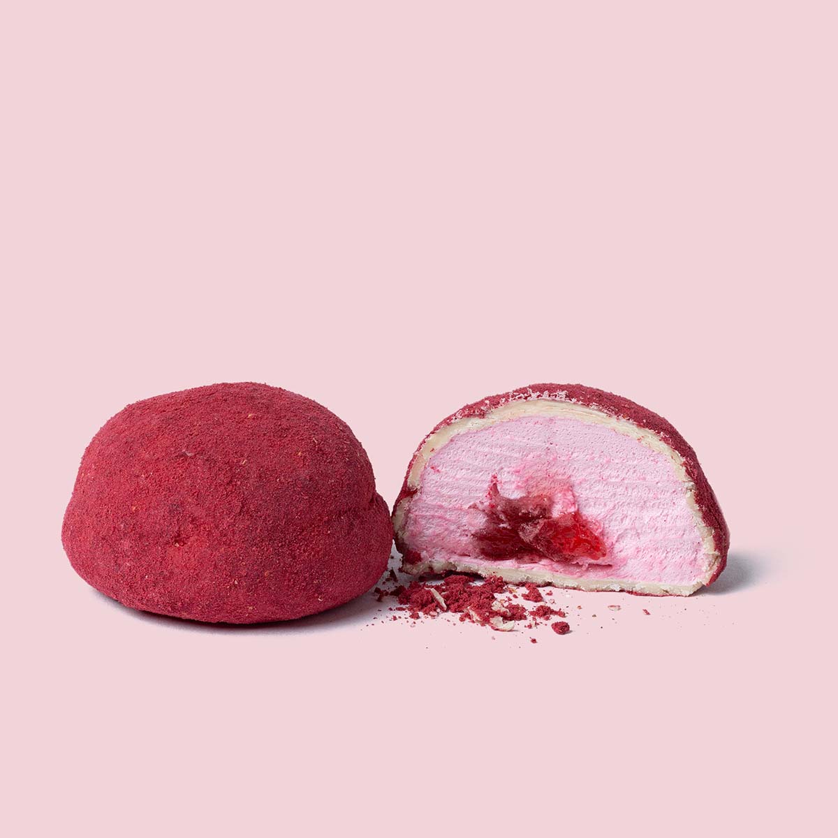 Nærbillede af skåret marshmallow med hvid chokolade, hindbær og fyld af jordbær på lyserød baggrund.