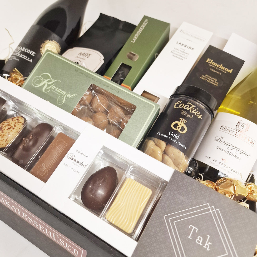 Eksklusiv gavekurv med rødvin, hvidvin, Summerbird chokolade og lækre delikatesser som en takkegave.