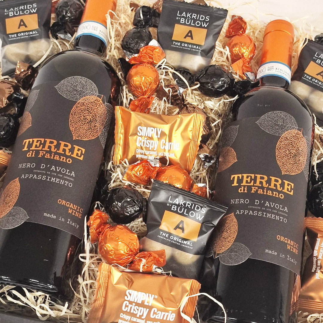 Gavekurv med Terre di Faiano rødvin, Lakrids by Bülow og Simply Chocolate chokolade i træuld.