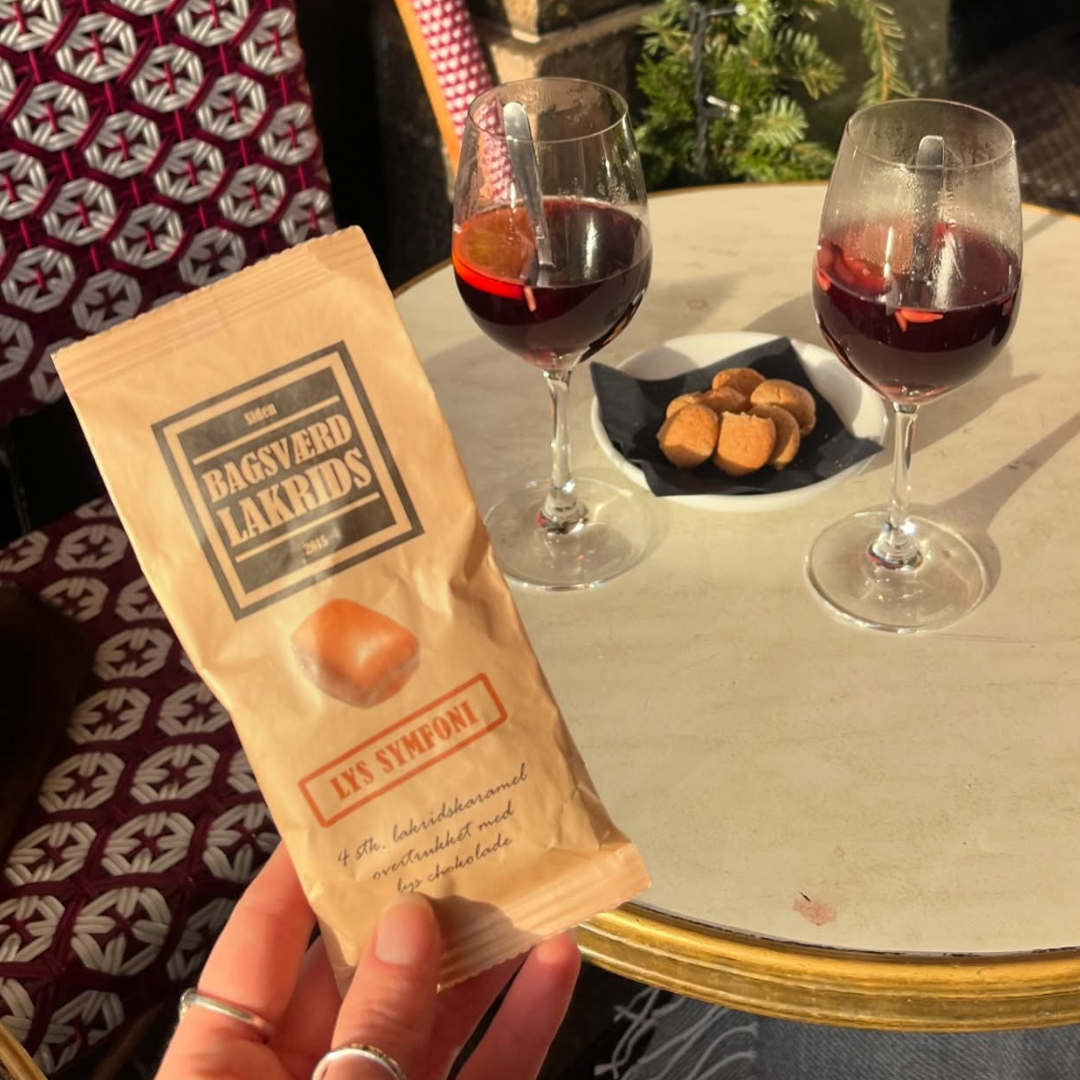 Bagsværd Lakrids Lys Symfoni lakridskaramel med chokolade ved siden af to glas gløgg.