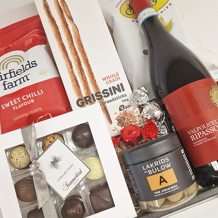 Gavekurv med spansk rødvin, Summerbird chokolade, Lakrids by Bülow og lækre delikatesser i røde nuancer.