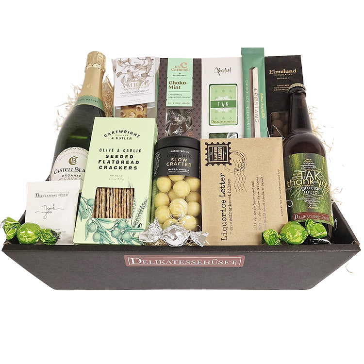 Luksuriøs gavekurv med mousserende vin, chokolade, lakrids og delikatesser i grønne og mint nuancer.