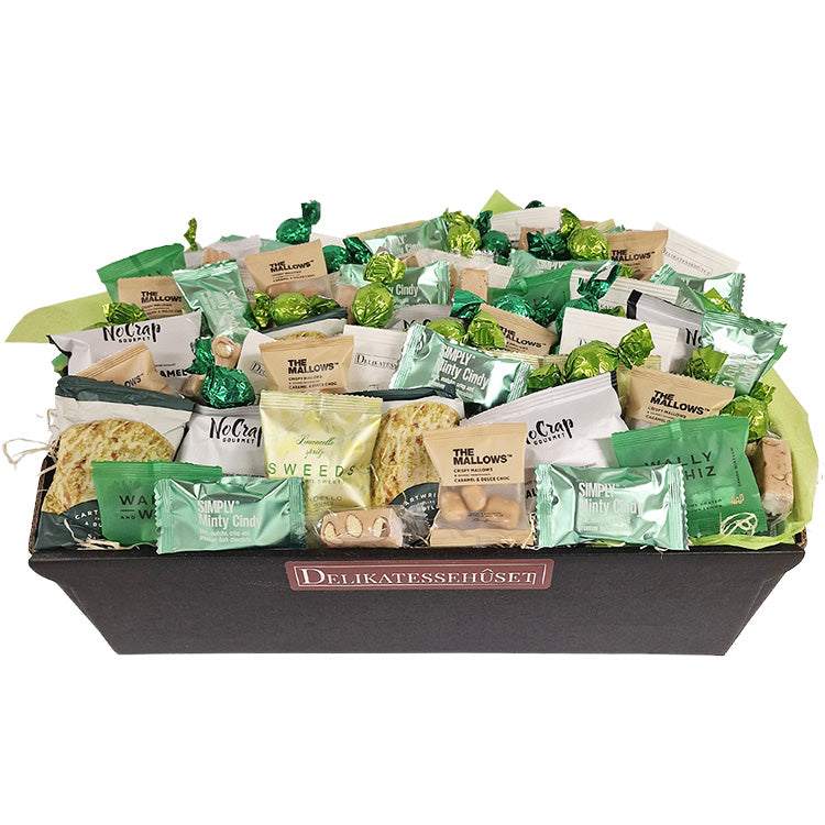 Gavekurv fyldt med forskellige grønne delikatesser, chokolade og snacks fra Delikatessehuset.